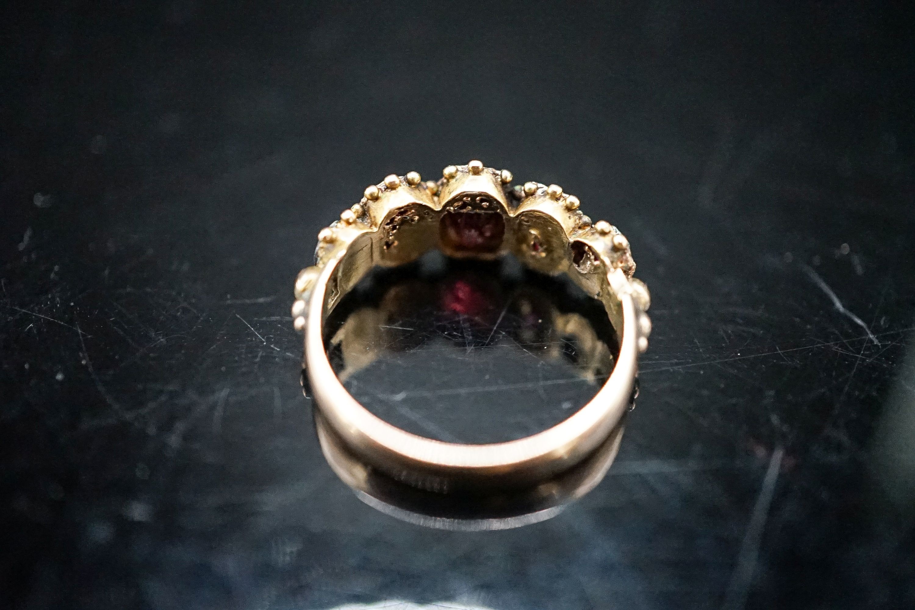 A 19th century yellow metal and graduated five stone garnet half hoop ring, size K, gross 2,.1 grams.